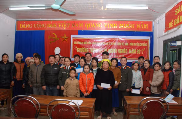 Đại diện Báo CAND, Công an huyện Bảo Lâm và BIDV tặng quà Tết cho người nghèo xã Quang Nam.