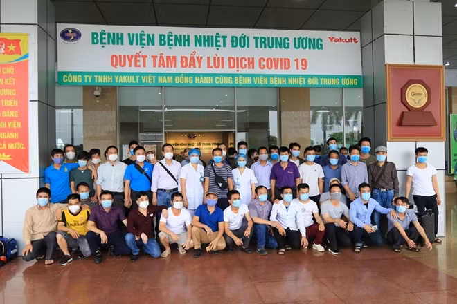 Đại diện Bệnh viện tặng hoa và chụp ảnh chung với các công dân hoàn thành thời gian cách ly bắt buộc.