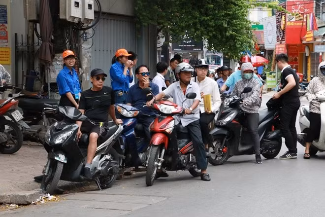 Các phụ huynh chờ con em vào trường nghe phổ biến quy chế thi.