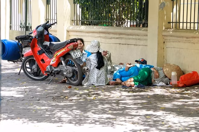 Trong khi nhóm công nhân nữ này đành tạm nghỉ trưa trên vỉa hè.
