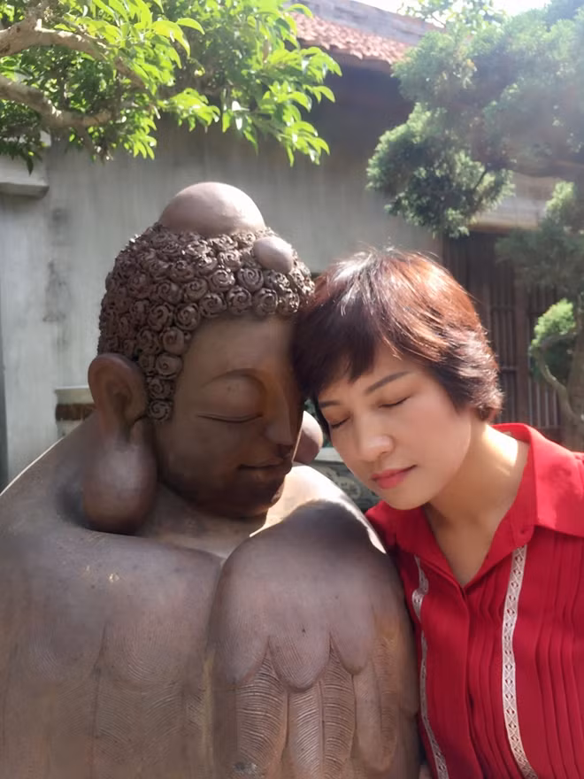Nhà báo Nguyễn Phương Liên bên bức tượng Phật ở Làng cổ Bát Tràng.