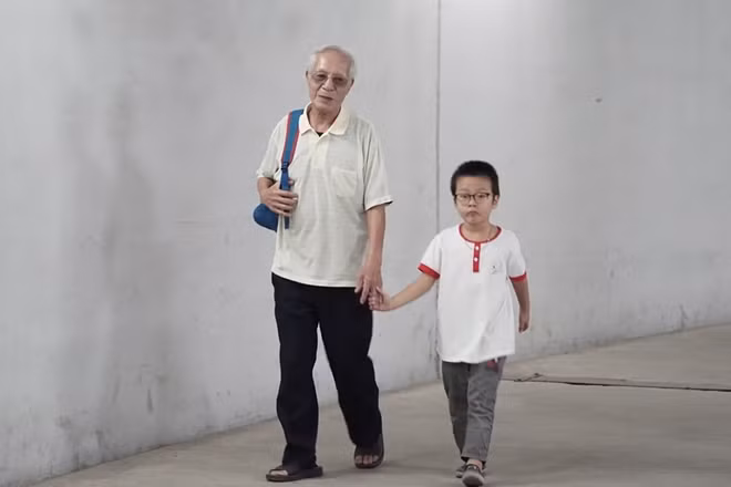 Một em nhỏ rời trường trở về nhà trong vòng tay người thân.