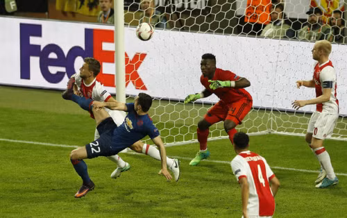 Mkhitaryan móc bóng ghi bàn vào lưới Ajax. Ảnh: Reuters.