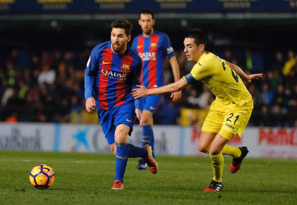 Để cho Villareal (phải) níu chân, Messi và đồng đội đã hoàn toàn hụt hơi so với Real Madrid.