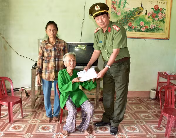 Đại diện Báo CAND khu vực Miền Trung - Tây Nguyên tặng sổ tiết kiệm cho cụ Nghê.