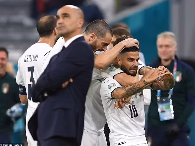 Vẻ mặt trầm ngâm của HLV đội tuyển Bỉ ông Roberto Martinez khi các cầu thủ Italia ăn mừng ngay bên cạnh.