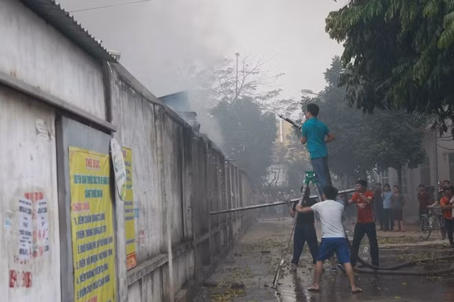 Trong khi những người khác thì phun nước vào để làm giảm nhiệt độ các gian hàng hy vọng giảm tốc độ của đám cháy trong chợ.