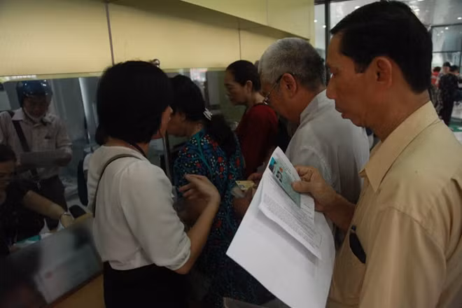 Người dân xếp hàng đăng ký làm thẻ xe buýt miễn phí tại Trung tâm Điều hành bến xe Kim Mã (Hà Nội).