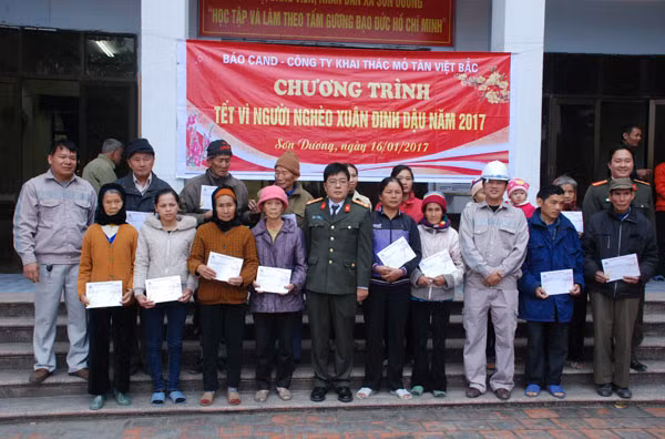 Đại tá Nguyễn Tuấn cùng đại diện Công ty Tân Việt Bắc và Công an huyện Hoành Bồ trao quà Tết cho người dân xã Sơn Dương.