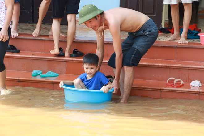 Trẻ em vùng này cũng phải tập làm quen với môi trường sống bị ngập nước trong mấy ngày qua. Tại địa bàn xã Tuyết Nghĩa toàn bộ các trường mầm non đã được cho nghỉ để đảm bảo an toàn cho các cháu trong những ngày này.