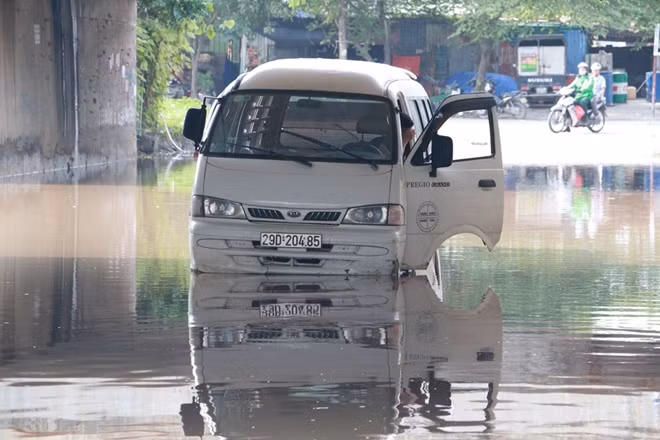 Tất nhiên với các đi này khiến nhiều phương tiện phải trả giá. Trong ảnh một chiếc xe ô tô đang chết máy chờ cứu hộ tại một hầm chui ngập nước tại Đại lộ Thăng Long.