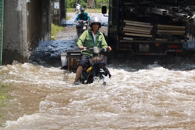 Trong khi người đi xe máy này suýt ngã vì "sóng nước" do chiếc xe tải chạy ngược chiều gây ra.