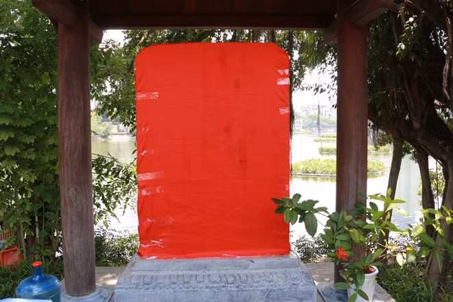 Bia đá xưa nằm ở nhà chứa bia ở giữa hòn đảo nhỏ, giờ khiêm tốn ở bên một góc đền.