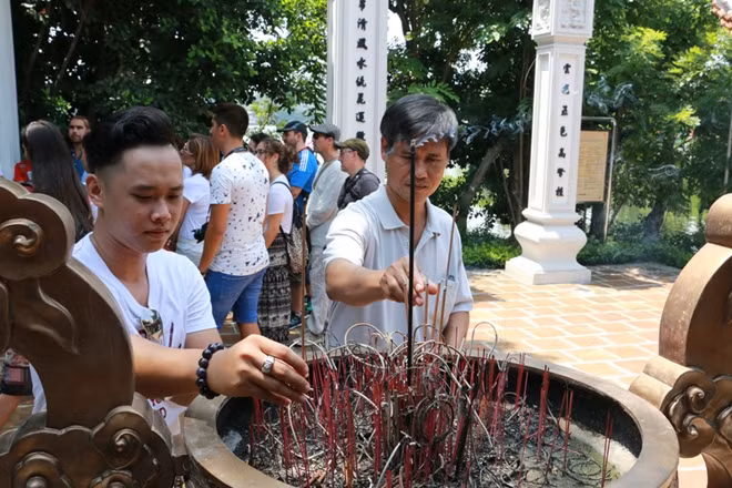 Mới được phục dựng nhưng đền vẫn thu hút không ít du khách. Một vị khách phương xa tới thắp hương tại đền vào sáng 28-8.