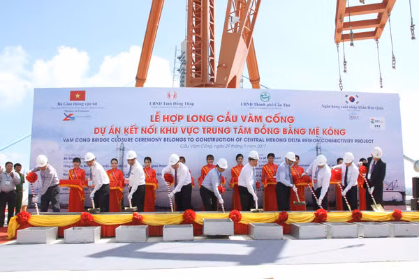 Các đại biểu tiến hành đổ bê tông hợp long cầu Vàm Cống.