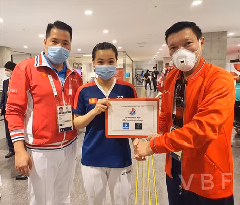 Thùy Linh (giữa) và HLV Ngô Trung Dũng nhận phần thưởng của Liên đoàn Cầu lông Việt Nam. Ảnh: VBF.