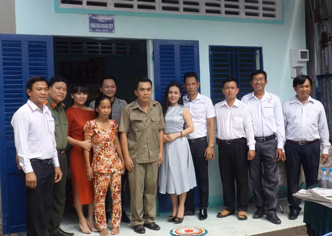 Đoàn công tác xã hội từ thiện và gia đình chị Phan Thị Kim Nguyên, trước căn nhà mới.