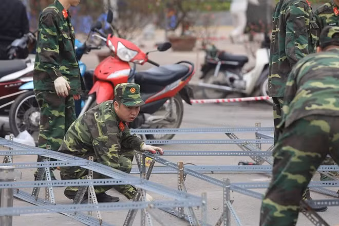giao thừa năm nay, Hà Nội sẽ tổ chức bắn pháo hoa tầm cao tại 6 điểm từ 0-0h15 ngày 25/1 (30/12 Âm lịch). Trong ảnh lực lượng bộ đội đang tiến hành lắp đặt các giá phóng cho việc bắn pháo hoa.