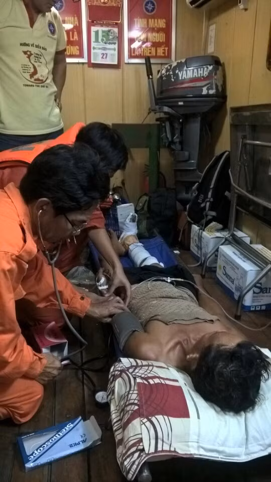 Thủy thủ tàu SAR 27-01 đưa ngư dân bị nạn lên tàu để sơ cứu trước khi đưa vào đất liền.
