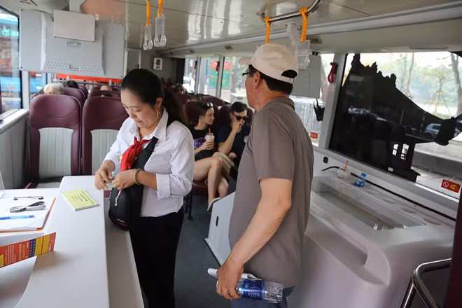 Hướng dẫn viên đang bán vé tham quan cho du khách.