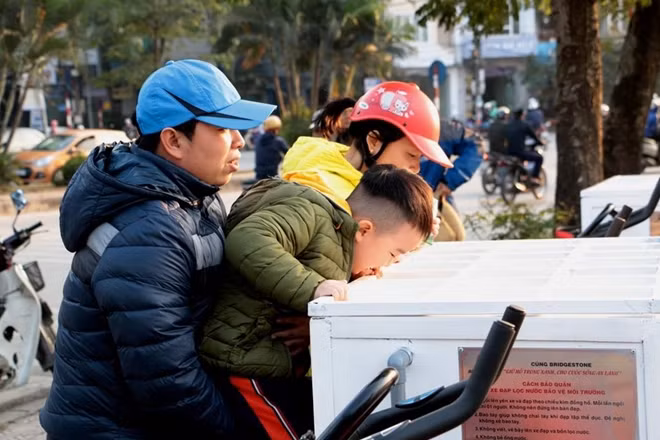 Bộ máy lọc nước đặc biệt thu hút sự chú ý của nhiều người. Trong ảnh một cậu bé tò mò nhìn nước hồ được lọc trong bể lắng.