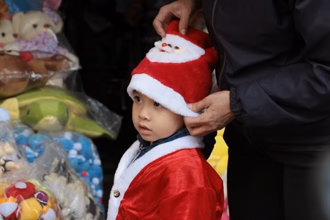 Một cậu bé với bộ quần áo của ông già Tuyết, Noel dường như đến sớm với em.