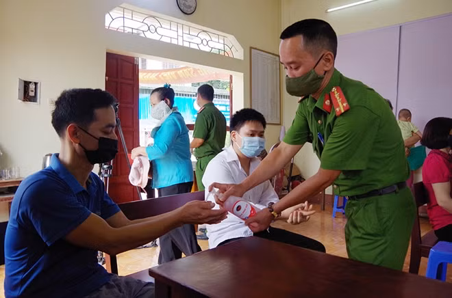Cán bộ, chiến sĩ Công an tỉnh Thái Nguyên hướng dẫn người dân rửa tay sát khuẩn khi đến làm CCCD.