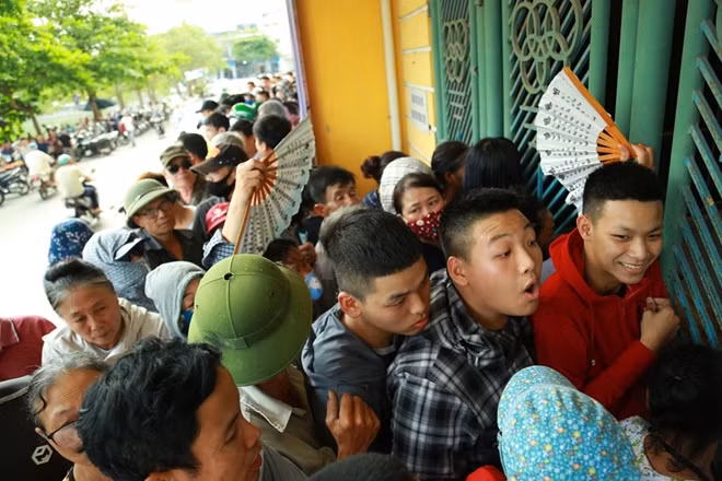 Càng gần đến giờ mở bán vé không khí càng nóng lên và lượng người tập trung quanh các quầy càng đông nghẹt bất chấp nắng nóng.