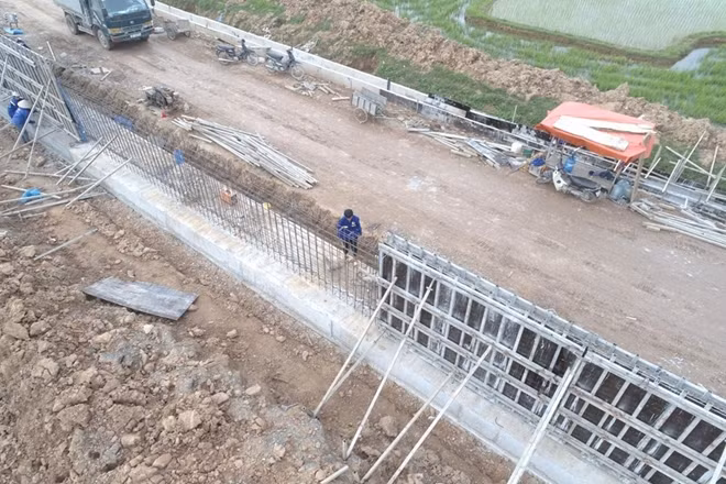 Theo đó một bức tường bê tông cốt thép ngăn lũ trên mặt đê.