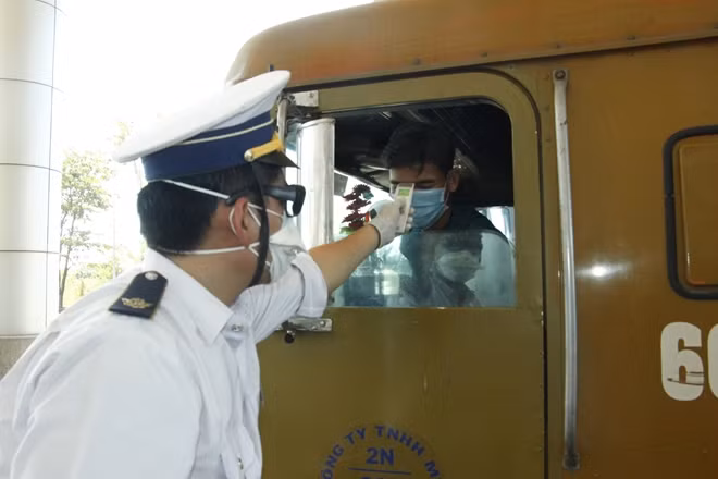 Nhân viên cửa khẩu quốc tế Hoa Lư, huyện Lộc Ninh, tỉnh Bình Phước đo thân nhiệt người từ Campuchia nhập cảnh vào Việt Nam.
