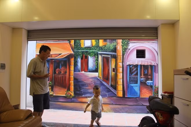 Nhìn từ trong nhà ra ngoài, bức tranh trở nên nổi bật hơn rất nhiều. Con ngõ nhỏ đầy rêu phong cũ kỹ được khoác lên mình tấm áo mới vô cùng lộng lẫy.