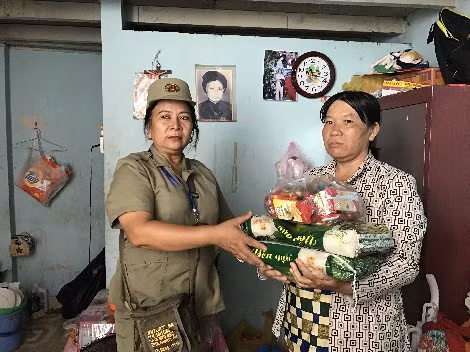 Bà Lê Kim Chung, bảo vệ tổ dân phố phường 13, quận Bình Thạnh đến thăm, tặng quà cho mẹ con chị Loan.