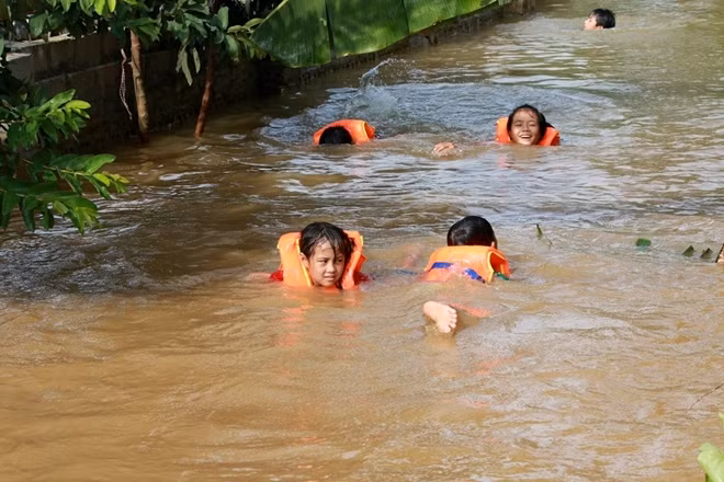 Buổi tập bơi diễn ra ngay tại con đường làng cạnh nhà nơi dòng nước lụt đã biến thành một con kênh nhỏ.