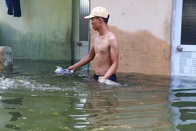 Cực chẳng đã nhiều người còn phải lội xuống nước để đẩy rác ra khỏi ra theo kiểu thủ công thế này.