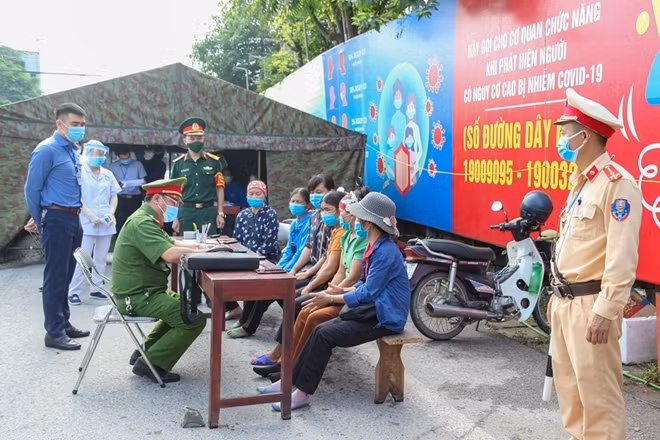 Lực lượng chức năng tuyên truyền, nhắc nhở và yêu cầu những người trốn trong thùng xe khai báo y tế.