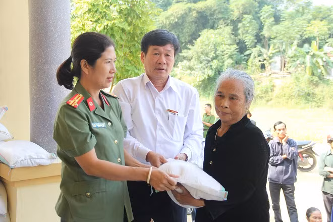 Đại diện Báo CAND và nhà tài trợ trao quà cho bà con.