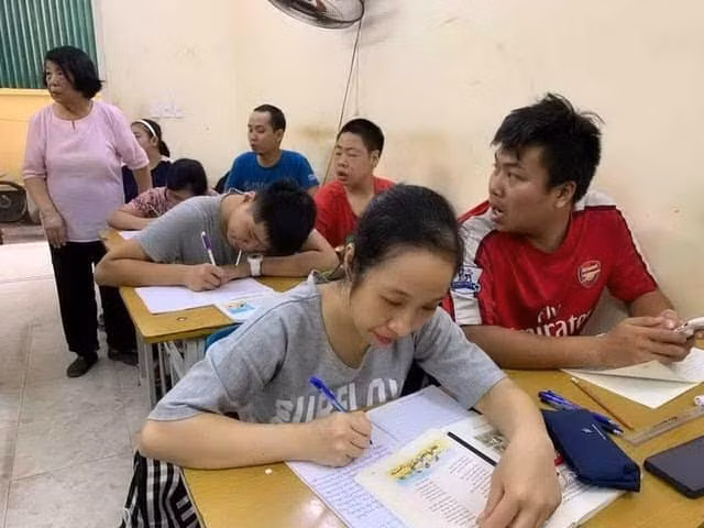 Bà Giáo Nguyễn Thị Côi bên cạnh những học sinh khuyết tật trong lớp học tình thương của mình.
