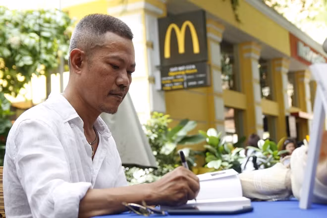 Nhạc sĩ Quốc Bảo ký tặng sách trong một buổi giao lưu.