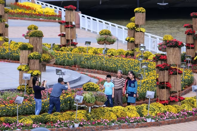 Trời Đà Nẵng ngày 26/1 hửng nắng sau ba ngày mưa dầm. Nhiều gia đình đi chơi xuân, chiêm ngưỡng tiểu cảnh hoa bên sông Hàn.