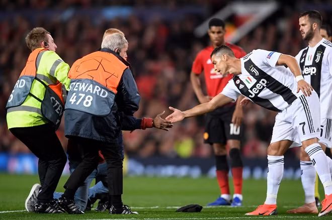 Tiền đạo Juventus không hề tỏ ra bực tức hay khó chịu vì hành động đó ngược lại còn tới bắt tay CĐV nọ. Ảnh: Getty.