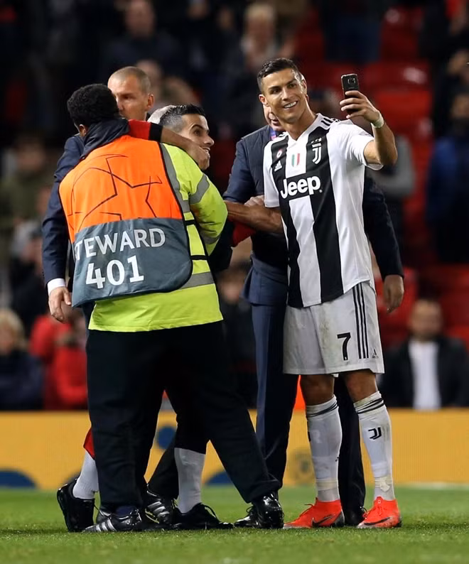 Những tưởng mọi chuyện đã kết thúc nhưng Ronaldo đã có một hành động bất ngờ khác. Ngôi sao 33 tuổi tiến đến vào chụp một kiểu ảnh chung với CĐV quá khích trên. Ảnh: Reuters.