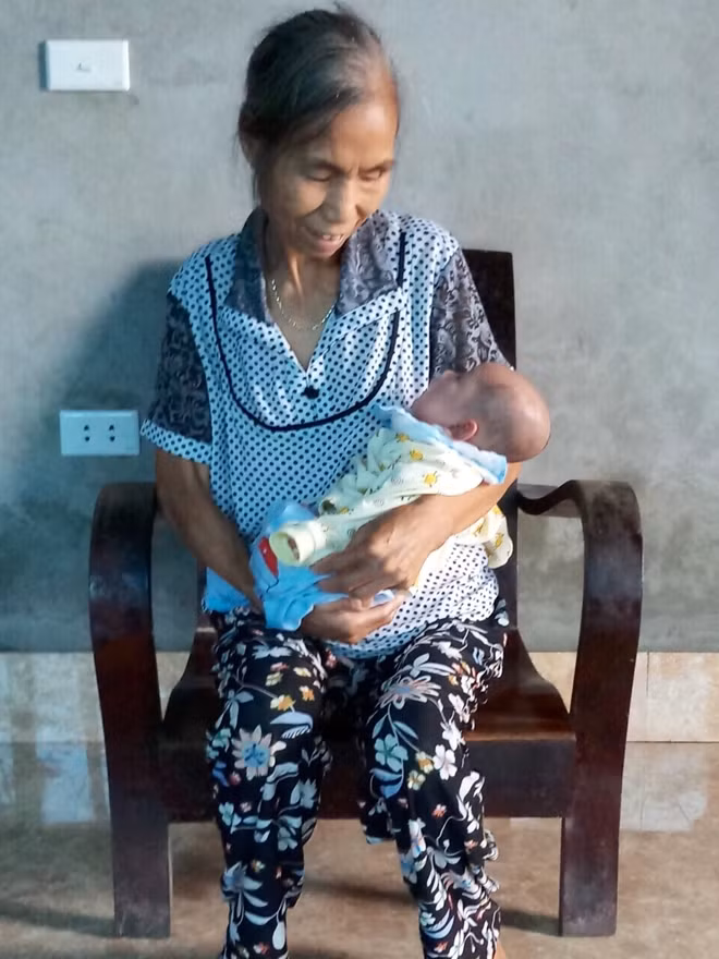 Cháu Minh trong vòng tay bà nội.