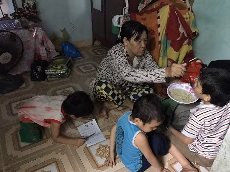 Những đứa trẻ nằm, ngồi la liệt trong căn phòng trọ chật chội, ẩm thấp.