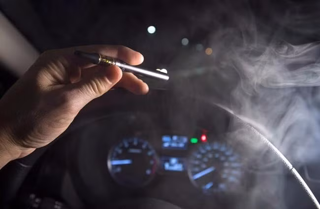 Khói từ máy xông hơi dầu cần sa được nhìn thấy khi người lái xe ngồi sau tay lái của một chiếc ôtô ở Vancouver vào ngày 14-11-2018.