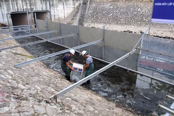 Do lớp bùn trên sông Tô Lịch quá dày, các chuyên gia Nhật Bản đã quây một khu vực sông đoạn gần đường Hoàng Quốc Việt, Cầu Giấy để xử lý .