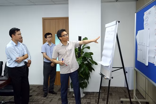 Phó Thủ tướng Vũ Đức Đam trao đổi với Nhóm truy vết. Ảnh: VGP.