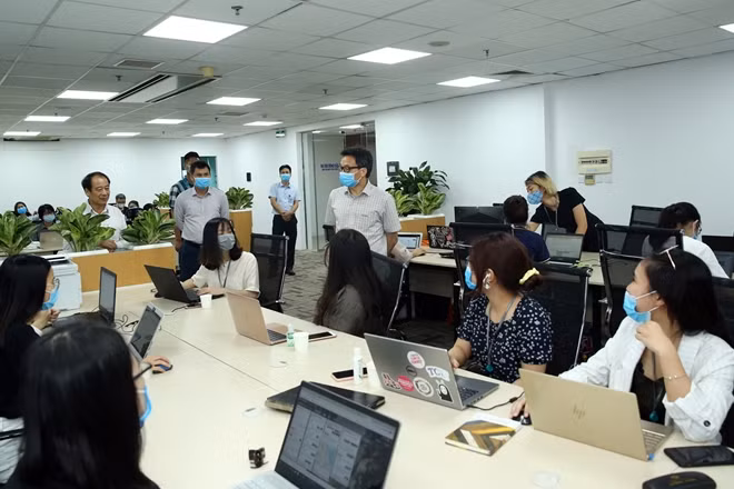 Phó Thủ tướng Vũ Đức Đam trò chuyện với các tình nguyện viên. Ảnh: VGP