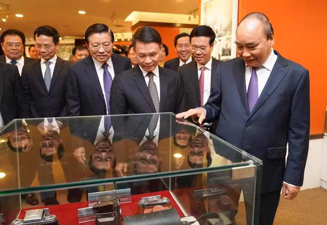 Thủ tướng Nguyễn Xuân Phúc và các đại biểu tham quan Phòng truyền thống của TTXVN. - Ảnh: VGP/Quang Hiếu