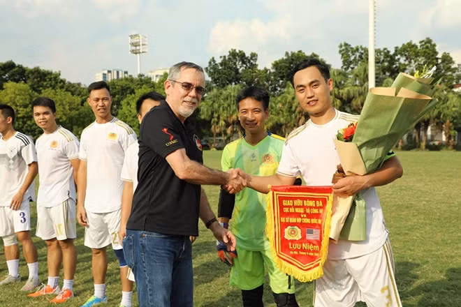 Ngài Joe Harms, Trưởng Phòng An ninh, ĐSQ Mỹ tại Việt Nam trao hoa và cờ lưu niệm cho Đội bóng Cục Đối ngoại, Bộ Công an.