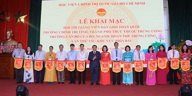 Đồng chí Nguyễn Xuân Thắng, Ủy viên Bộ Chính trị, Giám đốc Học viện Chính trị Quốc gia Hồ Chí Minh trao cờ lưu niệm cho các đoàn thi.